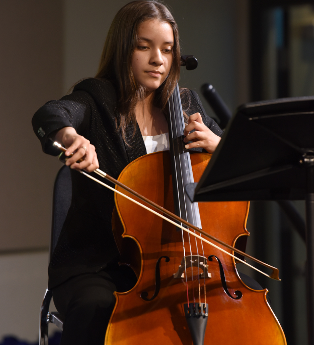 Teenage girl playing cello at spring recital