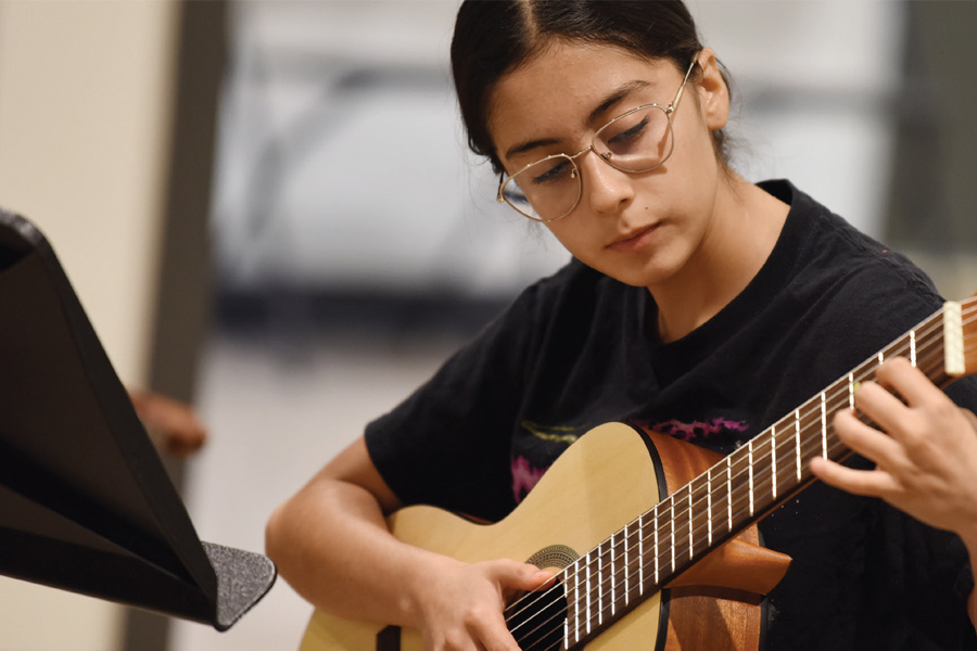 rosies-house-dark-hair-girl-playing-guitar